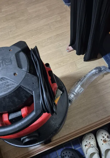 현관에 내려 둔 습식청소기와 흡입 호스
